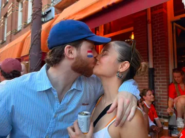 Joris and Mariana kissing, a Dutch flag painted on his cheek