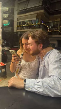 Mariana and Joris looking at a phone at night