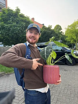 Joris pointing at the potted plant he is holding